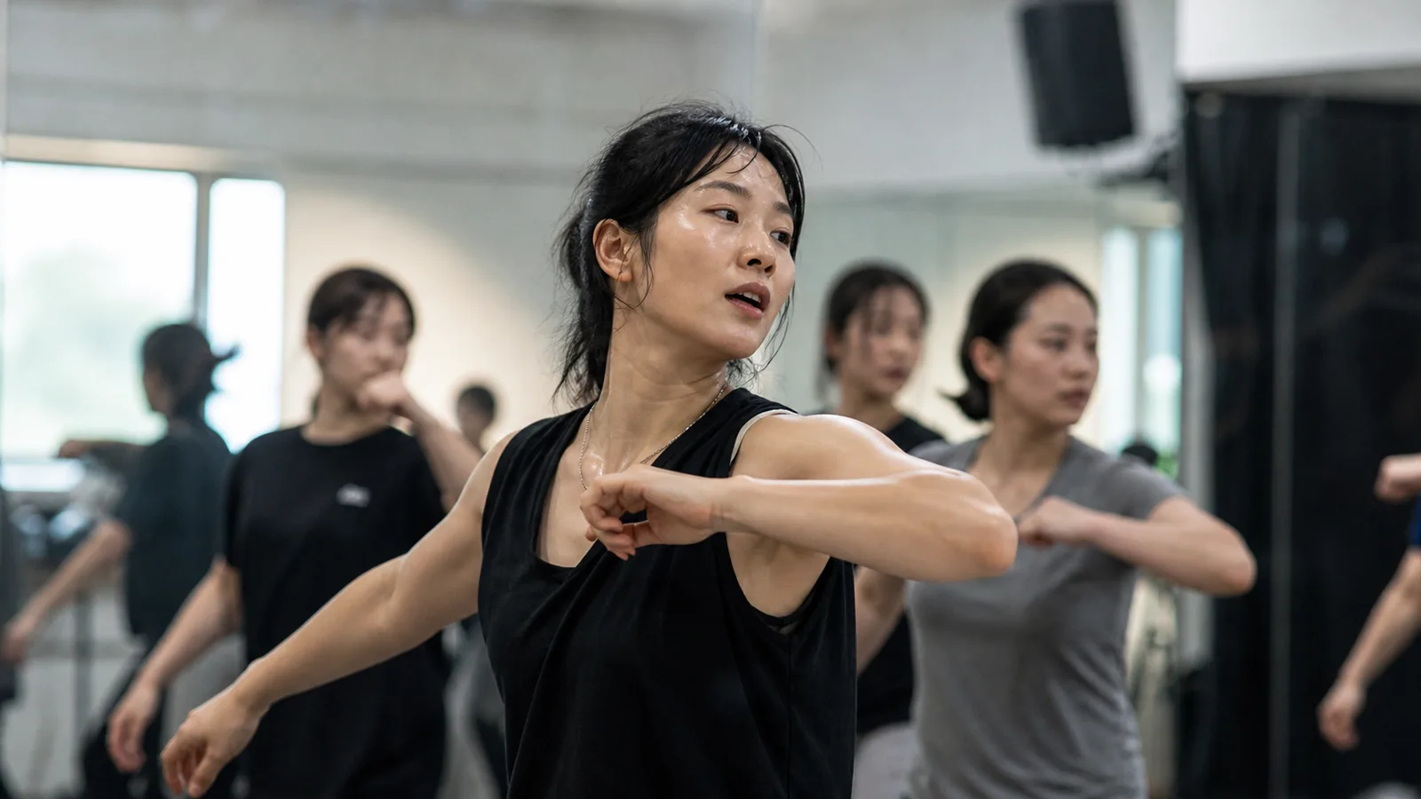 Choreographer leading dancers in a practice room