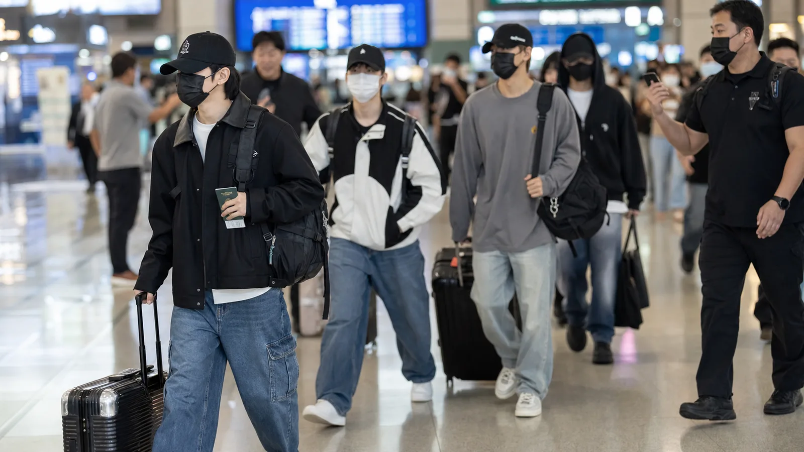 K-pop team departing for a world tour at an airport